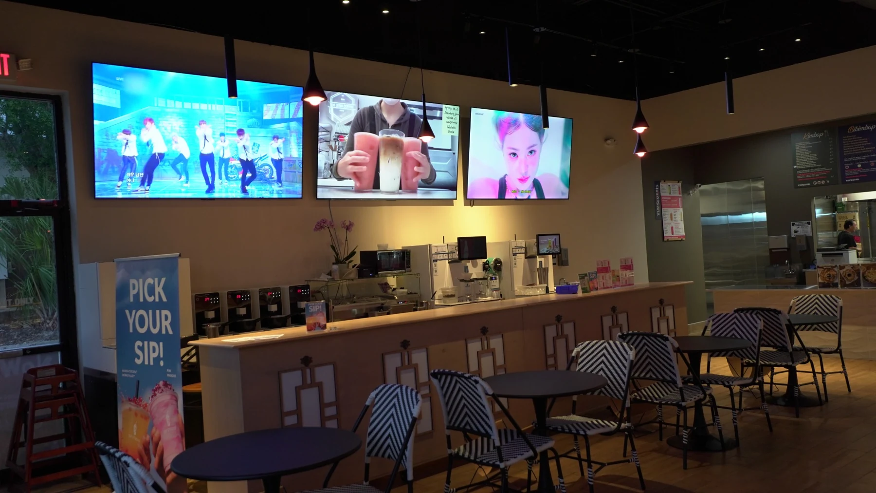 YumSem Eats dining room with the drink counter and television screens